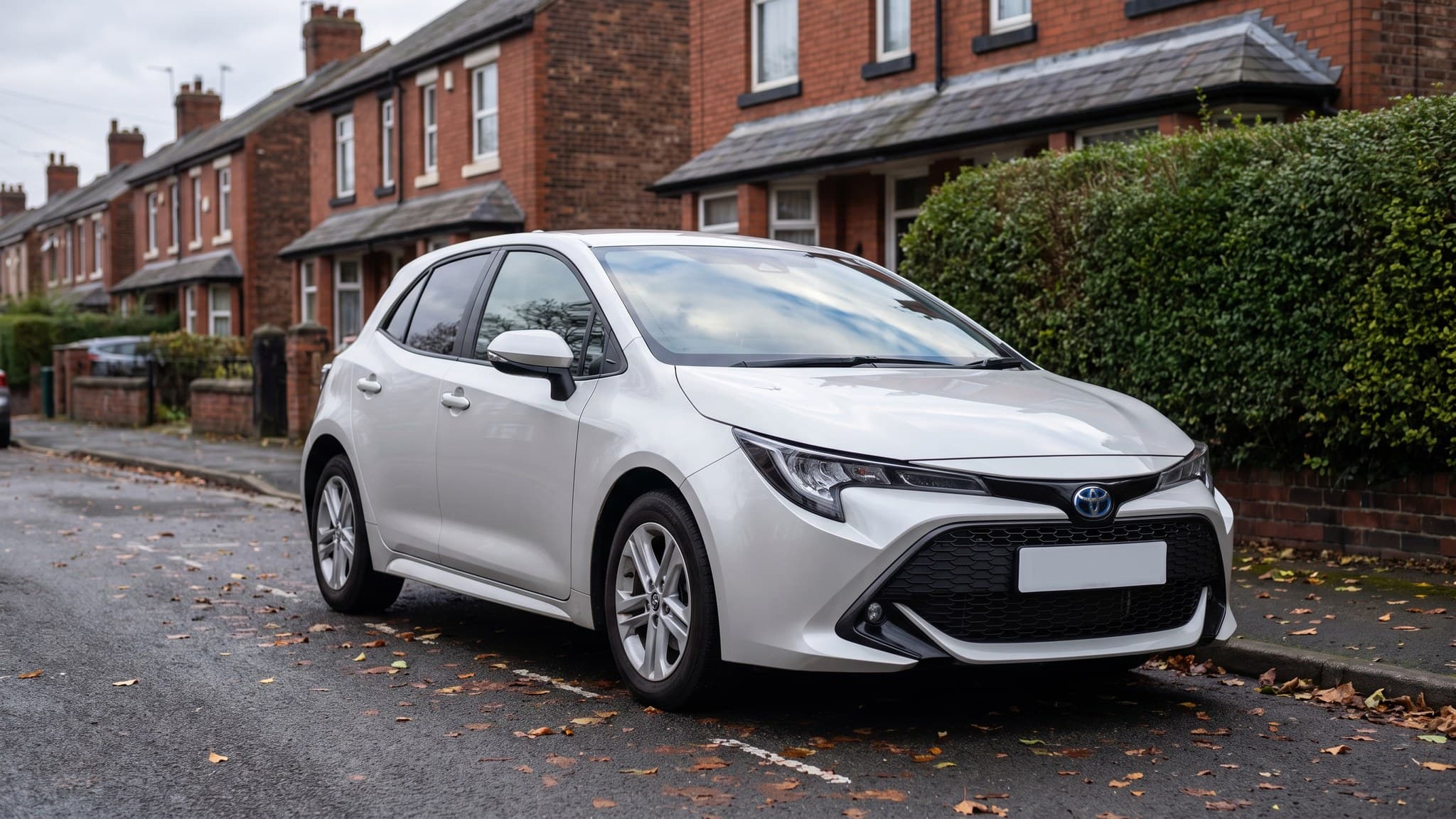 A white Toyota Corolla hybrid hatchback on a UK residential street